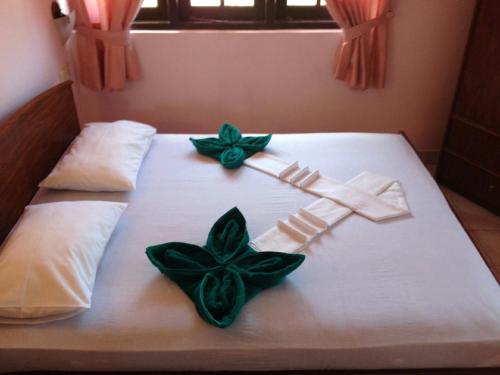 Una cama con flores verdes encima. en Hotel Red Rose, en Negombo