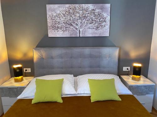 a bedroom with a large bed with two green pillows at Apartment Paola in Opatija