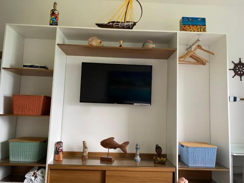a living room with a tv on a wall at Apart Hotel Marinas Tamandaré in Recife