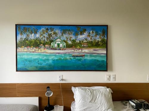 a painting hanging on a wall above a bed at Apart Hotel Marinas Tamandaré in Recife