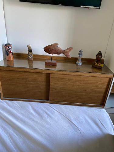 a wooden dresser with figurines on top of a bed at Apart Hotel Marinas Tamandaré in Recife