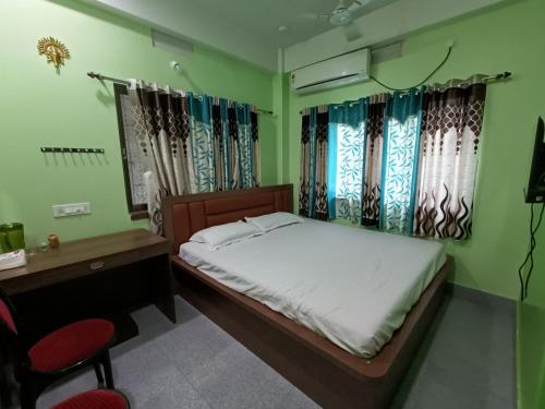 a bedroom with a bed and a desk and chairs at Ujjayanta Homestay in Agartala