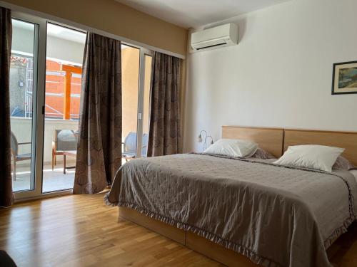 a bedroom with a bed and a sliding glass door at Room Novakovic in Biograd na Moru