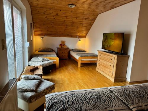 StašovにあるDům Stašovのベッド2台、薄型テレビが備わる客室です。