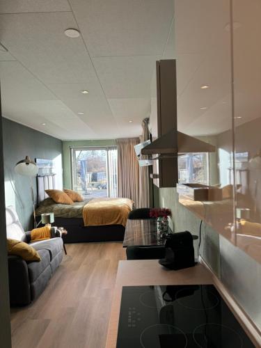 a living room with a bed and a couch in a room at De Gouwe Stek in Landsmeer