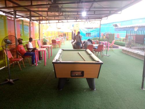 a pool table in a room with people sitting in chairs at D'Island Hotel and Club in Lekki