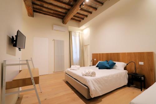 een slaapkamer met een bed en een flatscreen-tv bij [Soggiorno di Lusso] nel Centro Storico di Modena in Modena
