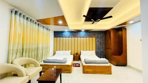 Cette chambre comprend deux lits et un ventilateur de plafond. dans l'établissement Hotel Sonar Bangla, à Rangamati