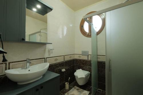 a bathroom with a sink and a glass shower at Lüks Bahçeli Özel Havuzlu Villa in Fethiye