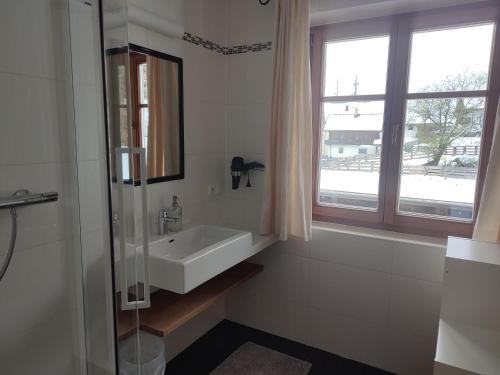 łazienka z umywalką i oknem w obiekcie Bauernhof Lienharter w mieście Obertilliach