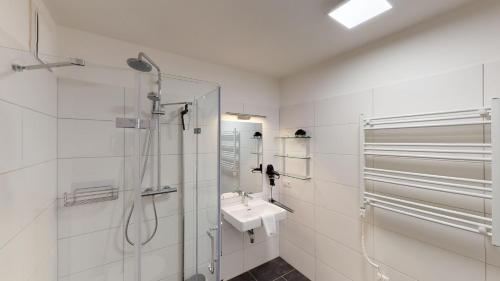 a white bathroom with a sink and a shower at Kitzview Idyll in Zell am See