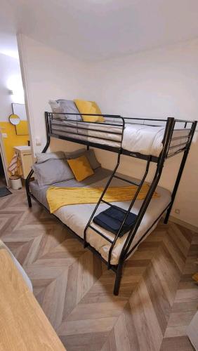 a bunk bed sitting in a room with a wooden floor at Monastère in Ville-dʼAvray