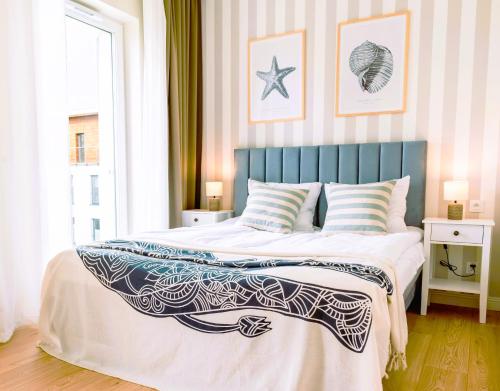 a bedroom with a large bed with a blue headboard at Marina Nautica - nowy, parking podziemny, winda, Netflix i Max, TV55" in Iława