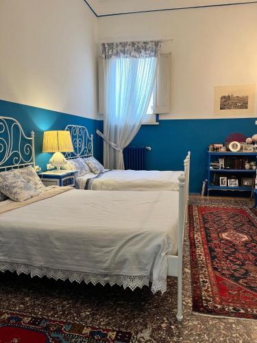 a bedroom with two beds and a blue wall at Fascino settecentesco in Alessano