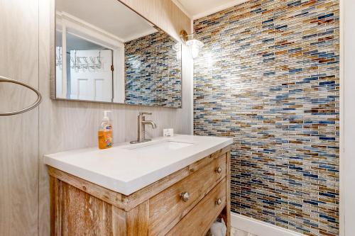 baño con lavabo y pared de mosaico en The Snowflake Sanctuary, en Dover