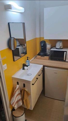 a small kitchen with a sink and a mirror at Monastère in Ville-dʼAvray