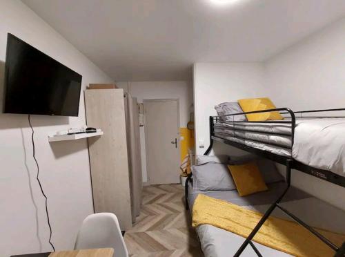 a small room with a bunk bed and a flat screen tv at Monastère in Ville-dʼAvray
