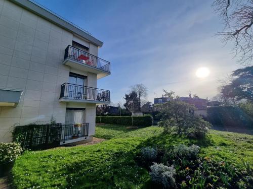 ein Gebäude mit einem Balkon mit Sonne im Hintergrund in der Unterkunft La Rose in Croissy-sur-Seine