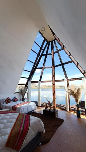 a room with two beds and a large window at WIÑAY TITICACA LODGE in Puno