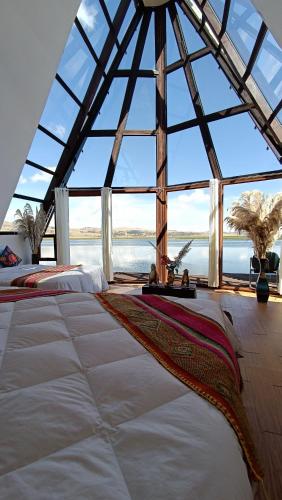 Zimmer mit einem großen Fenster und einem großen Bett in der Unterkunft WIÑAY TITICACA LODGE in Puno