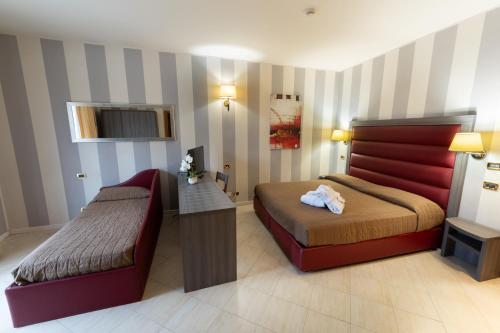a hotel room with two beds and a television at Grand Hotel Elite in Cascia