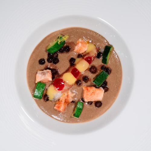 a bowl of soup with vegetables on a white plate at Grand Hotel Elite in Cascia