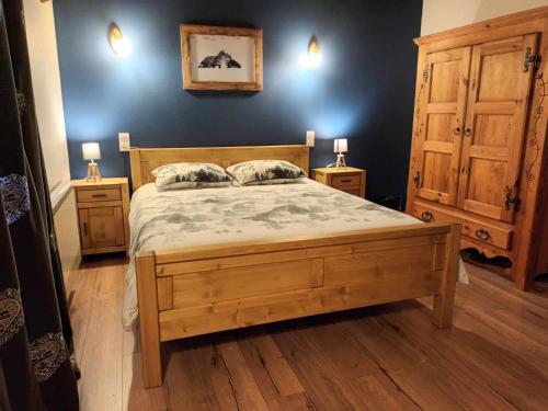 1 dormitorio con 1 cama de madera y 2 mesitas de noche en Chambres d'hôte des 3 Marches, en Lamoura
