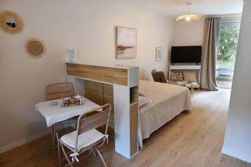 - un salon avec un lit et une table dans l'établissement Ange - Wifi, Terrasse, parking à proximité, mon séjour à Arbent, à Arbent