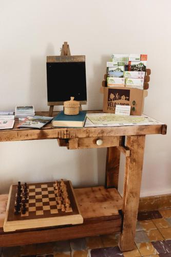 a desk with a computer and a chessboard on it at Gîte de l'Escanson un temps pour soi in Robion en Luberon