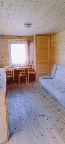 a room with a bed and a table and a window at Bursztynowe Domki in Władysławowo
