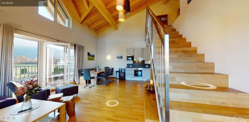 a living room with a staircase and a dining room at Apart-Chalet Kitzblick in Zell am See