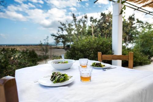 a table with two plates of food and a drink at Sea Breeze Beach House in Skiros