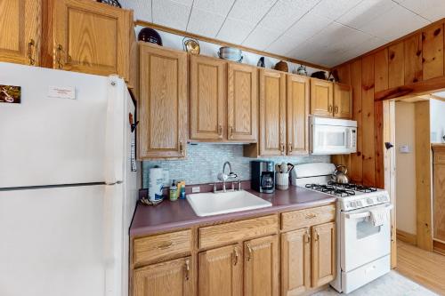a kitchen with wooden cabinets and a white refrigerator at River Road Retreat in Chestertown