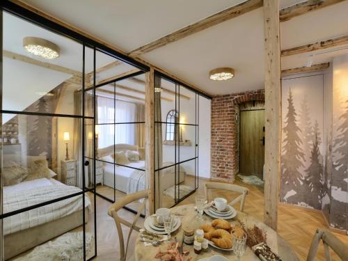 a room with a table and a bed and glass walls at CENTRUM 47 komfortowy, stylowy, apartament na deptaku, parking gratis in Karpacz