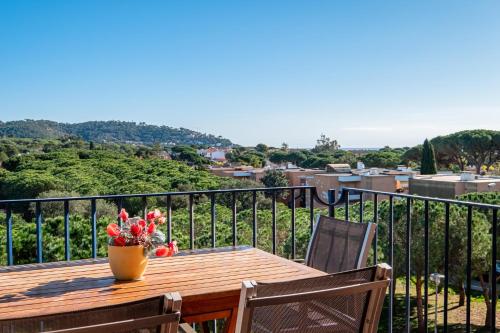 a wooden table with a vase of flowers on a balcony at DS-1 Calella de Palafrugell 6 Pax in Calella de Palafrugell