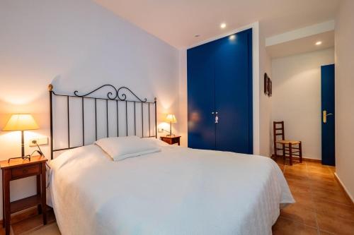 a bedroom with a large white bed and blue doors at DS-1 Calella de Palafrugell 6 Pax in Calella de Palafrugell