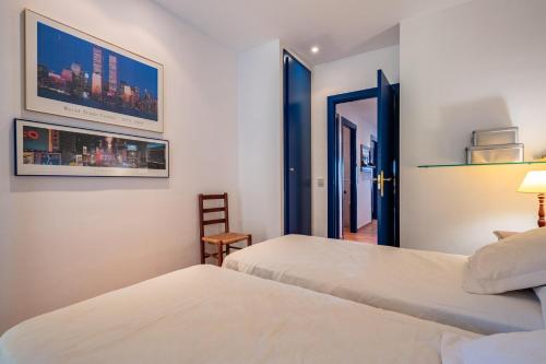 a hotel room with two beds and a chair at DS-1 Calella de Palafrugell 6 Pax in Calella de Palafrugell