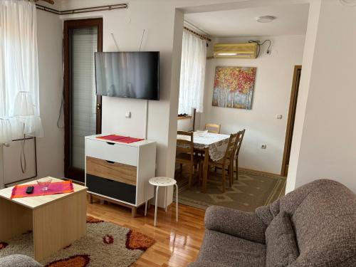 uma sala de estar com um sofá e uma mesa em Apartman LENKA em Pirot