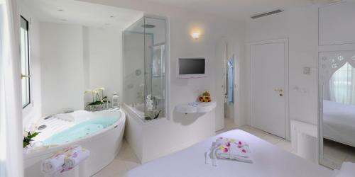 een witte badkamer met een bad en een douche bij Hotel Al Cavallino Bianco in Riccione