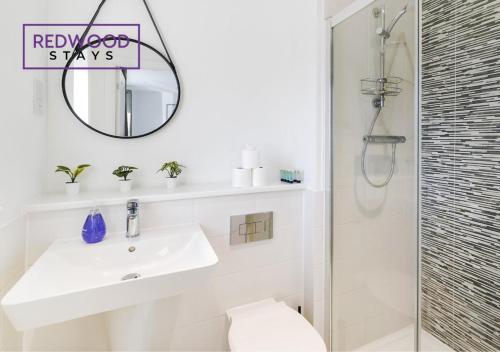 a white bathroom with a sink and a shower at BRAND NEW! 3 Bed 2 Bath House, NEAR HOSPITAL, With FREE x2 Parking & Wi-Fi By REDWOOD STAYS in Basingstoke