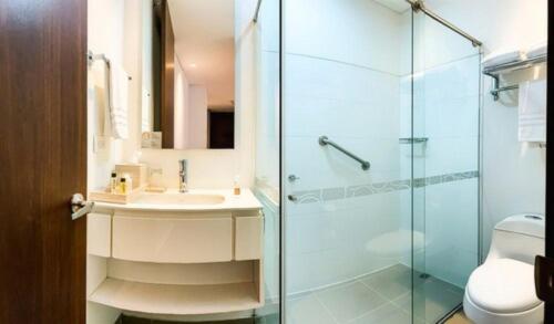 a bathroom with a glass shower and a sink at Quo Quality Hotel in Manizales