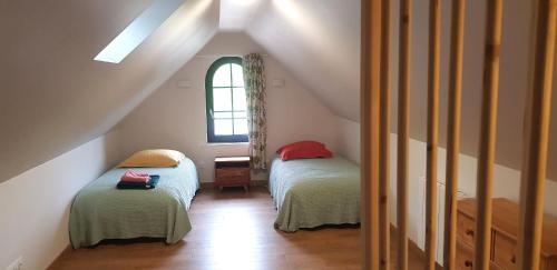 une chambre mansardée avec deux lits et une fenêtre dans l'établissement Gîte 3km Etretat, à Bénouville