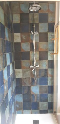 La salle de bains est pourvue d'une douche et d'un mur carrelé. dans l'établissement Gîte 3km Etretat, à Bénouville