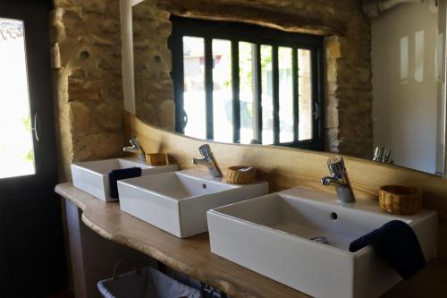 een badkamer met 2 wastafels voor een spiegel bij Gîte de l'Escanson un temps pour soi in Robion en Luberon