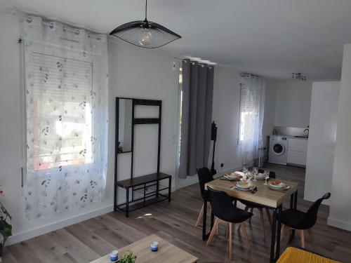 een woonkamer met een tafel en stoelen en een keuken bij Chambre privée in Tarbes