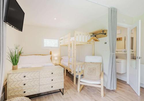 um quarto com um beliche e uma cómoda em Luxury Silver Birch Lodge: Hot Tub/BBQ/Fire Pit em Toppesfield