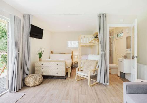 a bedroom with a bunk bed and a desk at Luxury Silver Birch Lodge: Hot Tub/BBQ/Fire Pit in Toppesfield
