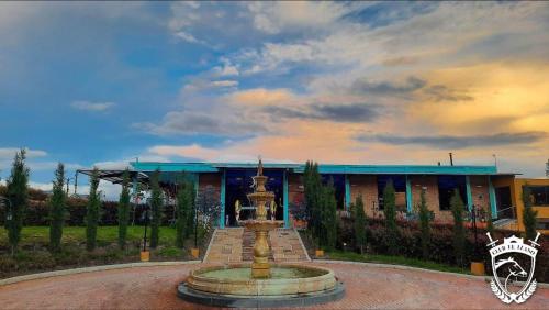 a water fountain in front of a building at Hotel Club el Llano in Combita