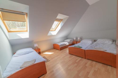a bedroom with two beds and two windows at Dom przy Wangu Karpacz in Karpacz