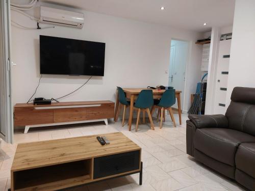 un salon avec un canapé et une télévision au mur dans l'établissement Appartement vue sur le port, à Martigues